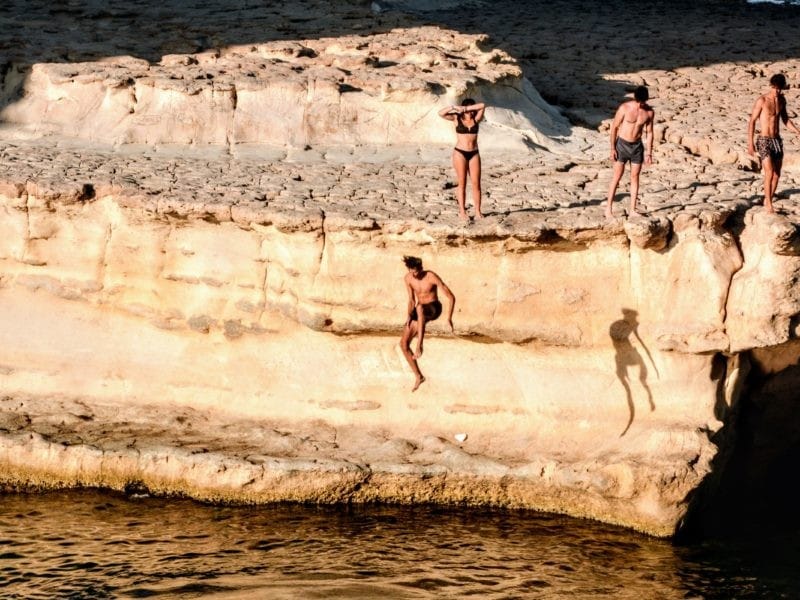 chicos saltando al mar de un acantilado Viajar a Malta